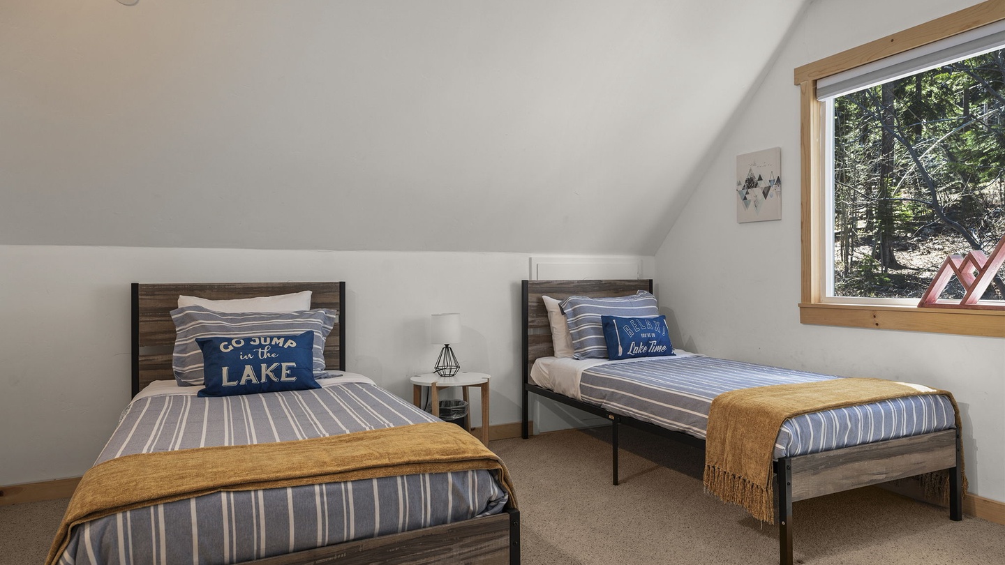 Rest peacefully in your cozy twin bedroom, where soft linens and forest views create the perfect lakeside retreat sanctuary.