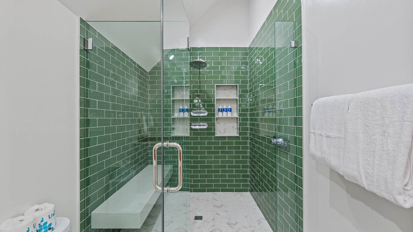 Rejuvenate in your own spa-like sanctuary, where emerald subway tiles and rain shower create a refreshing escape after exploring the area.