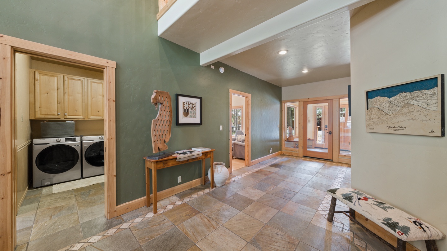 Step into your mountain getaway's warm and welcoming entryway, featuring rich wood accents, natural stone tile, and thoughtful touches like convenient laundry access and stunning alpine design.