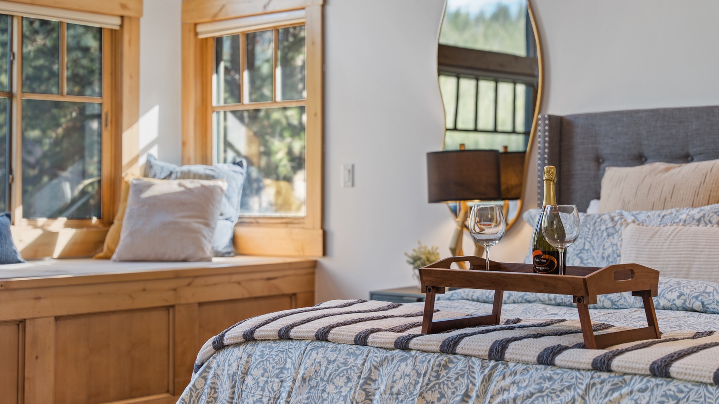 Your peaceful retreat awaits—picture yourself unwinding here with a glass of champagne, natural light streaming through beautiful wood-framed windows, and plush bedding inviting total relaxation.