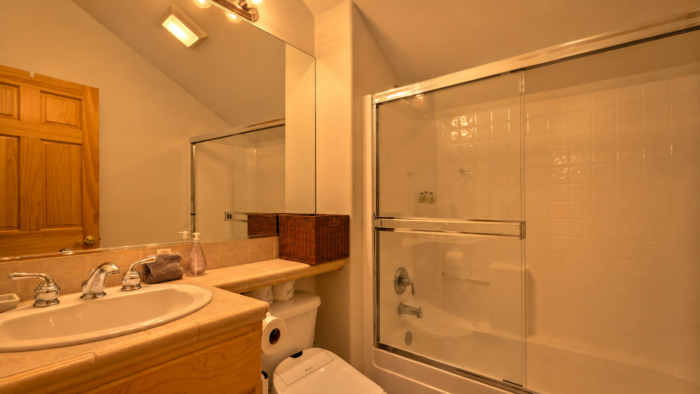 Step into your private bathroom featuring a sleek tub-shower combo, warm lighting, and plenty of counter space to help you unwind after each adventure.
