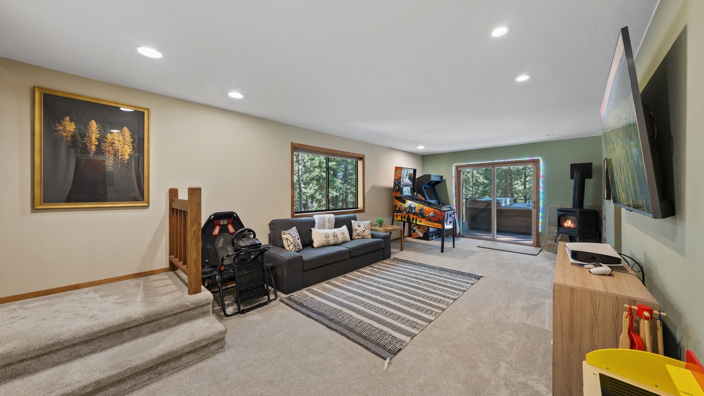 Sink into the plush sofa or cozy up beside the wood-burning stove as natural light streams through the glass doors. Your peaceful retreat awaits, where forest views and warm modern design come together perfectly.