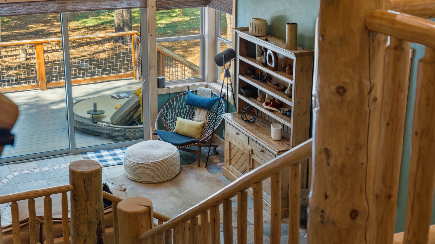 Curl up in your cozy seating nook and watch the natural beauty unfold through floor-to-ceiling windows opening to your private deck, where rustic wood details create a warm, inviting retreat.