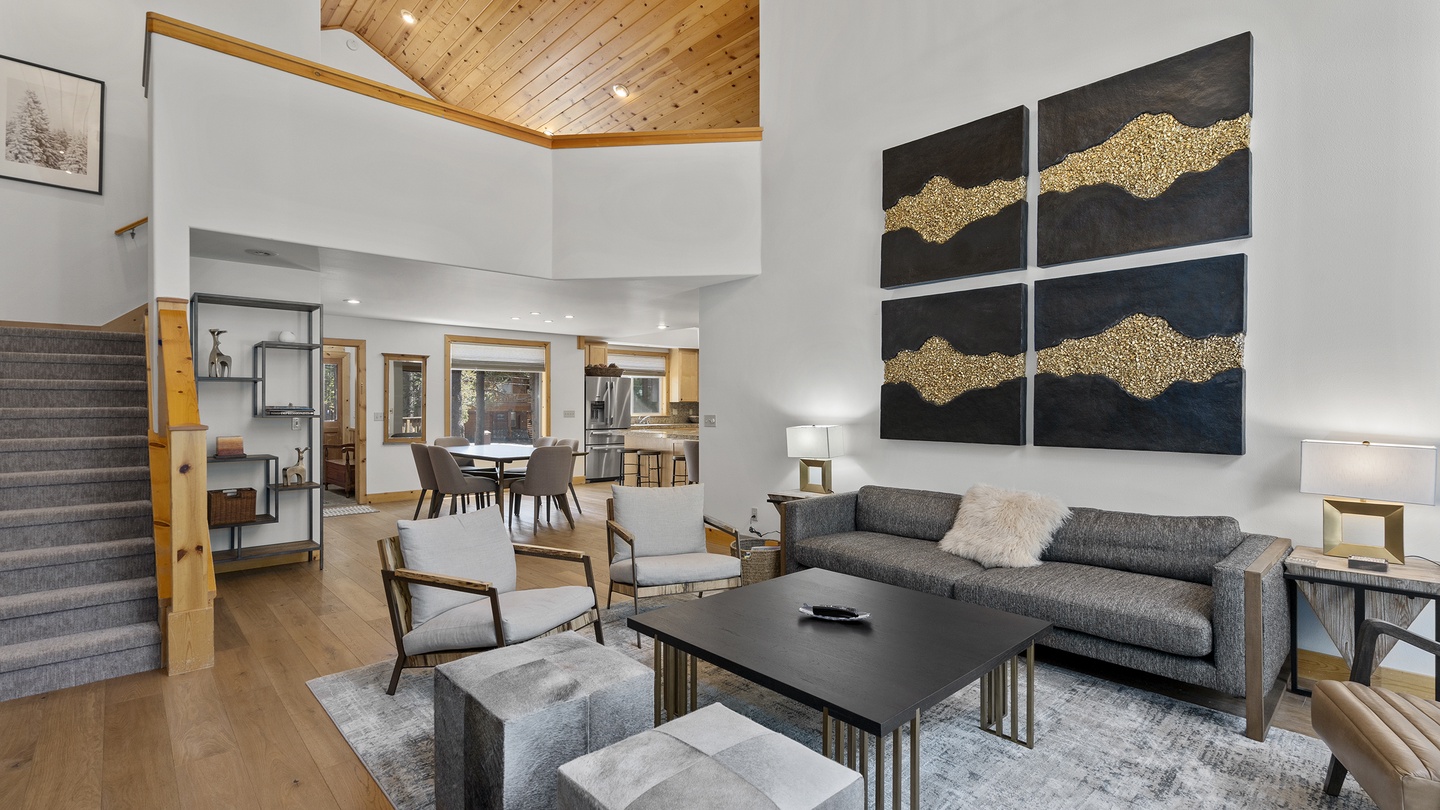 Settle into your spacious living area where soaring wood ceilings meet modern comfort. Your open-concept retreat flows effortlessly from lounging to dining, bathed in natural light for relaxed mountain evenings.
