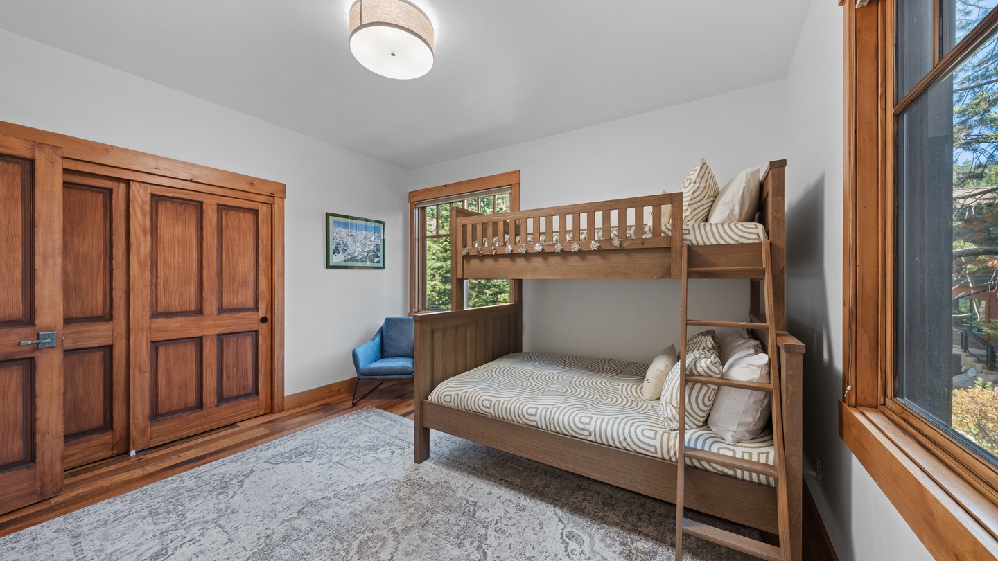Perfect for families, your cozy bunk room features warm wood tones and plenty of natural light streaming through large windows. Rest easy after a day of adventure, with storage and space for everyone to unwind together.