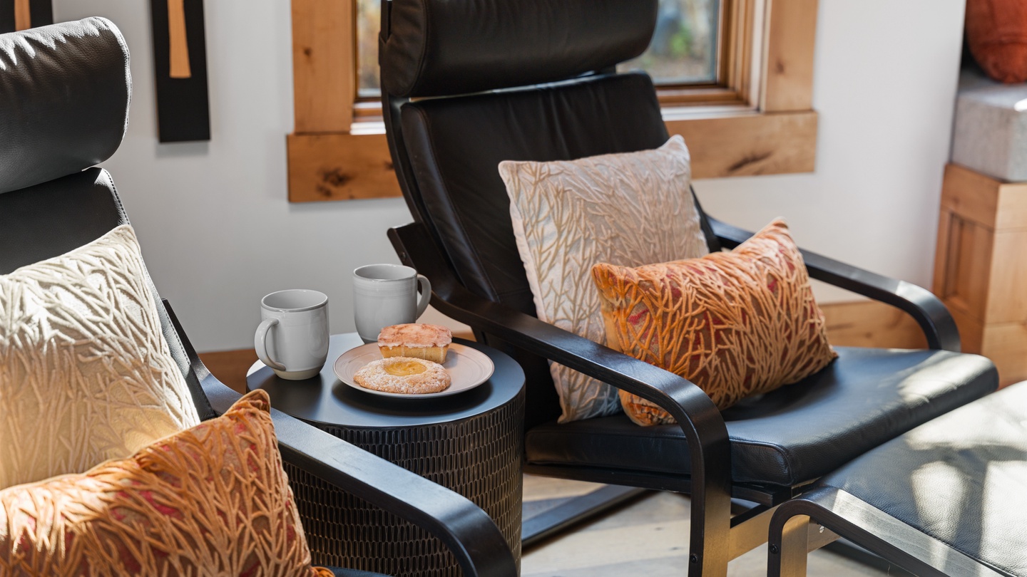 Settle into plush seating and enjoy a peaceful moment with your morning coffee, surrounded by natural light and warm wood tones that make you feel instantly at home.