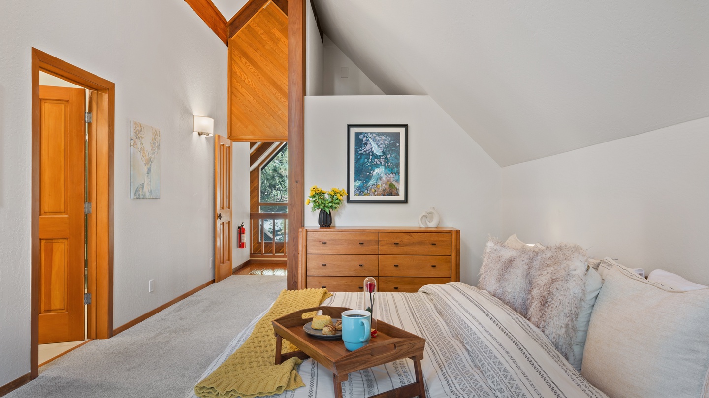 Unwind in your inviting bedroom sanctuary, where vaulted ceilings and warm wood accents create a cozy alpine retreat. Natural light pours through skylights, while plush bedding and thoughtful touches await you.