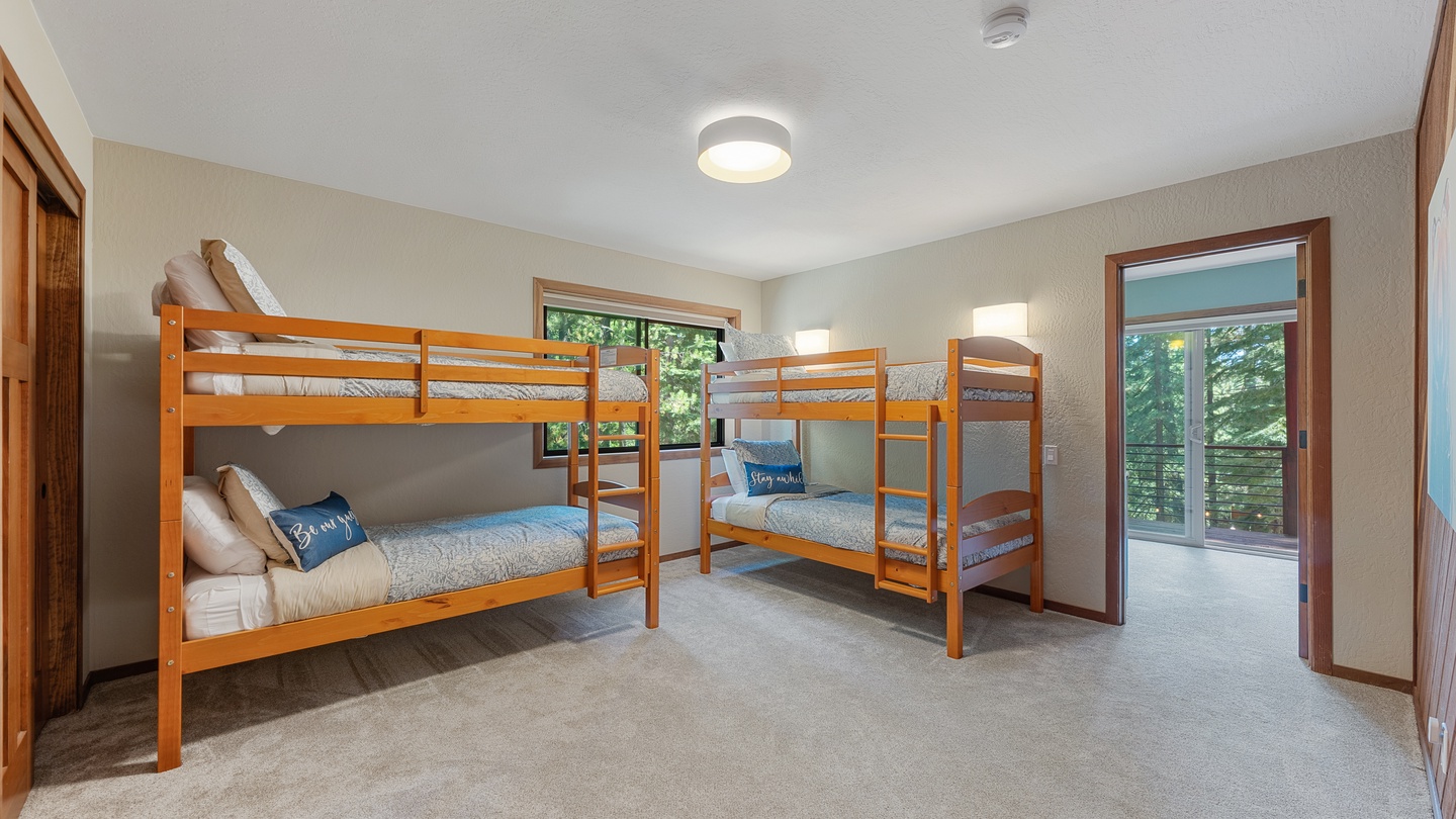 Your group will love this bright bunk room with four comfortable beds and private balcony access—perfect for kids or friends sharing space.