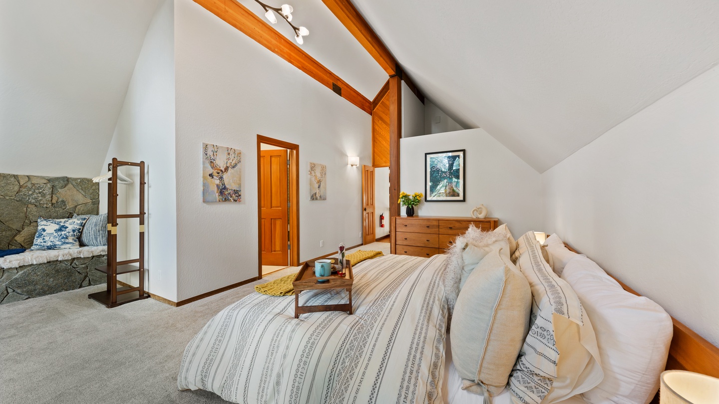 You'll love the vaulted ceilings and cozy yet airy feel of this charming bedroom. Drift off under warm wood beams and wake to soft natural light filling your personal retreat.