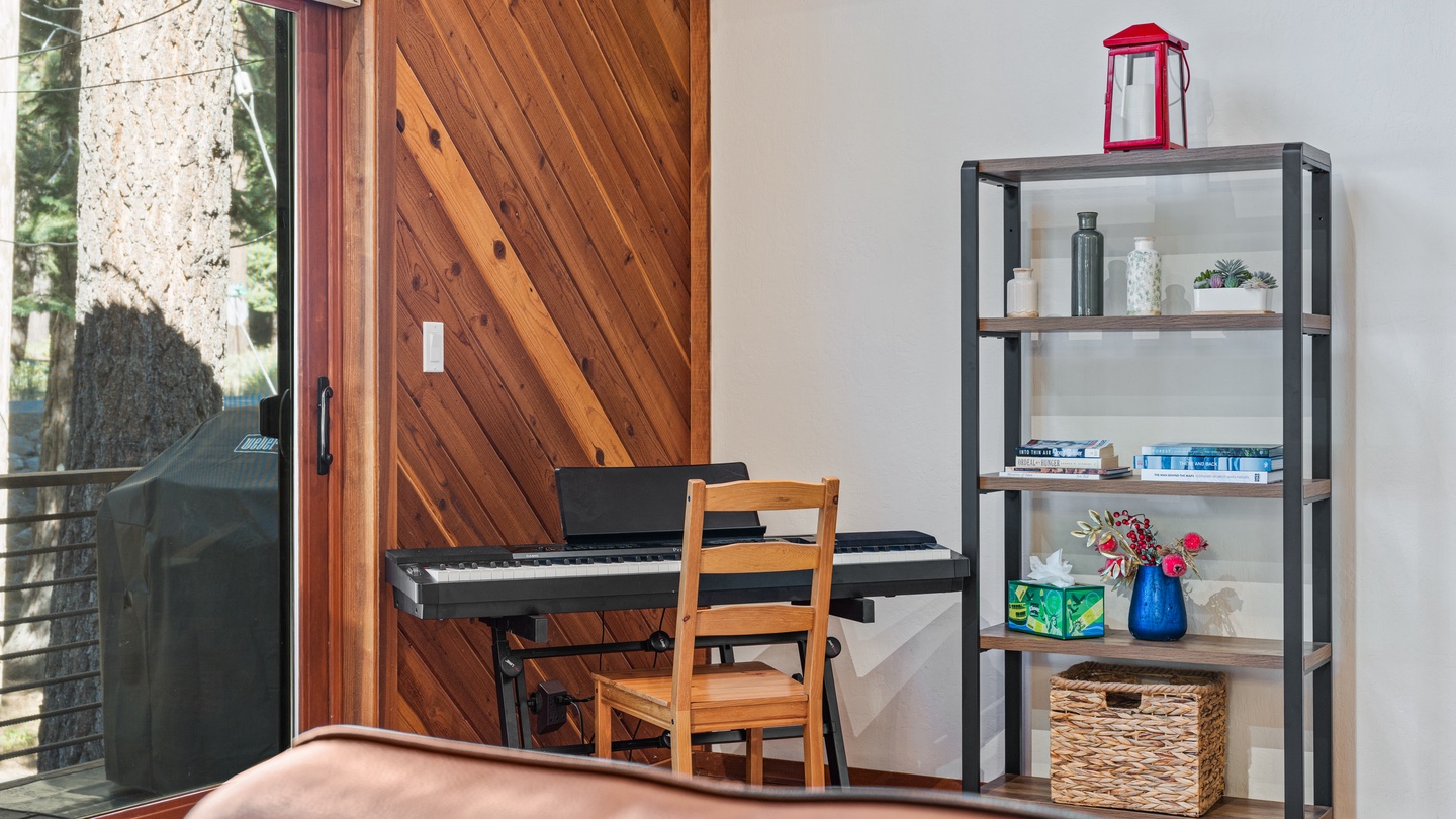 A cozy corner with a piano awaits your creative moments, while shelves display personal touches and a glass door opens to your private outdoor retreat.