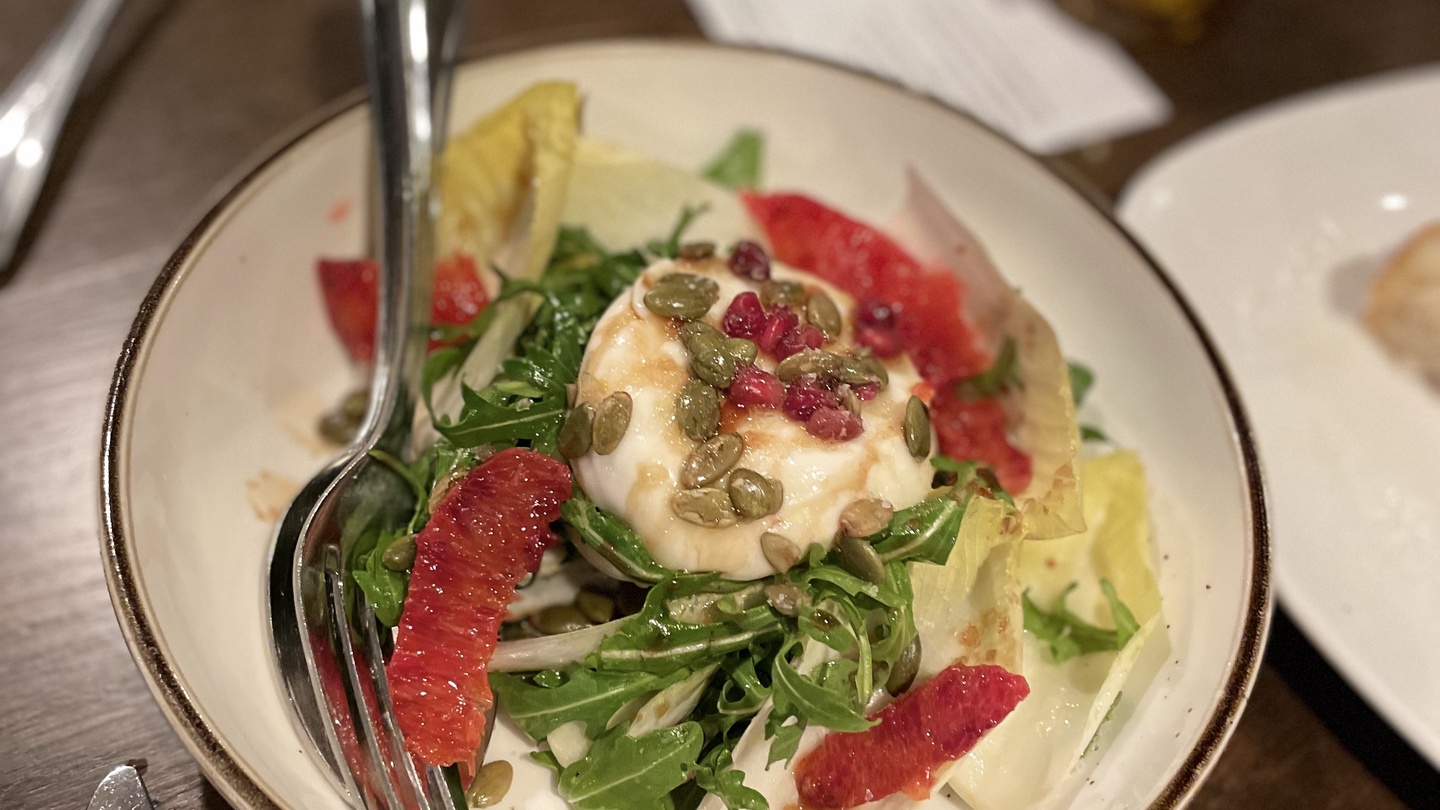 Fresh gourmet salad awaits your palate with creamy cheese, vibrant greens, and colorful garnishes perfectly plated for your dining pleasure.