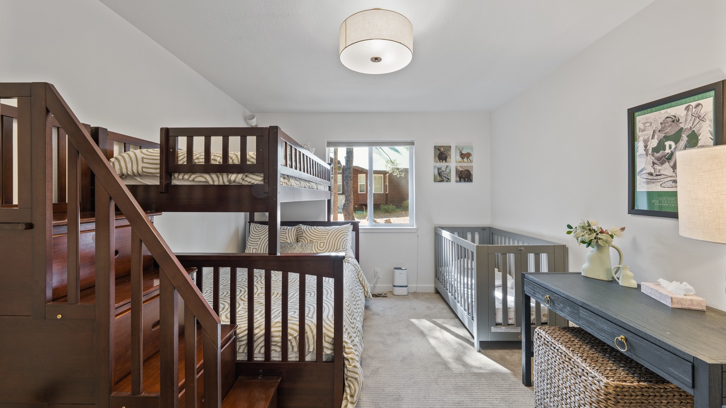 Thoughtfully designed sleep space features bunk beds and a crib, perfect for families traveling together. Natural light fills the room through large windows, creating a bright and welcoming atmosphere for your little ones.