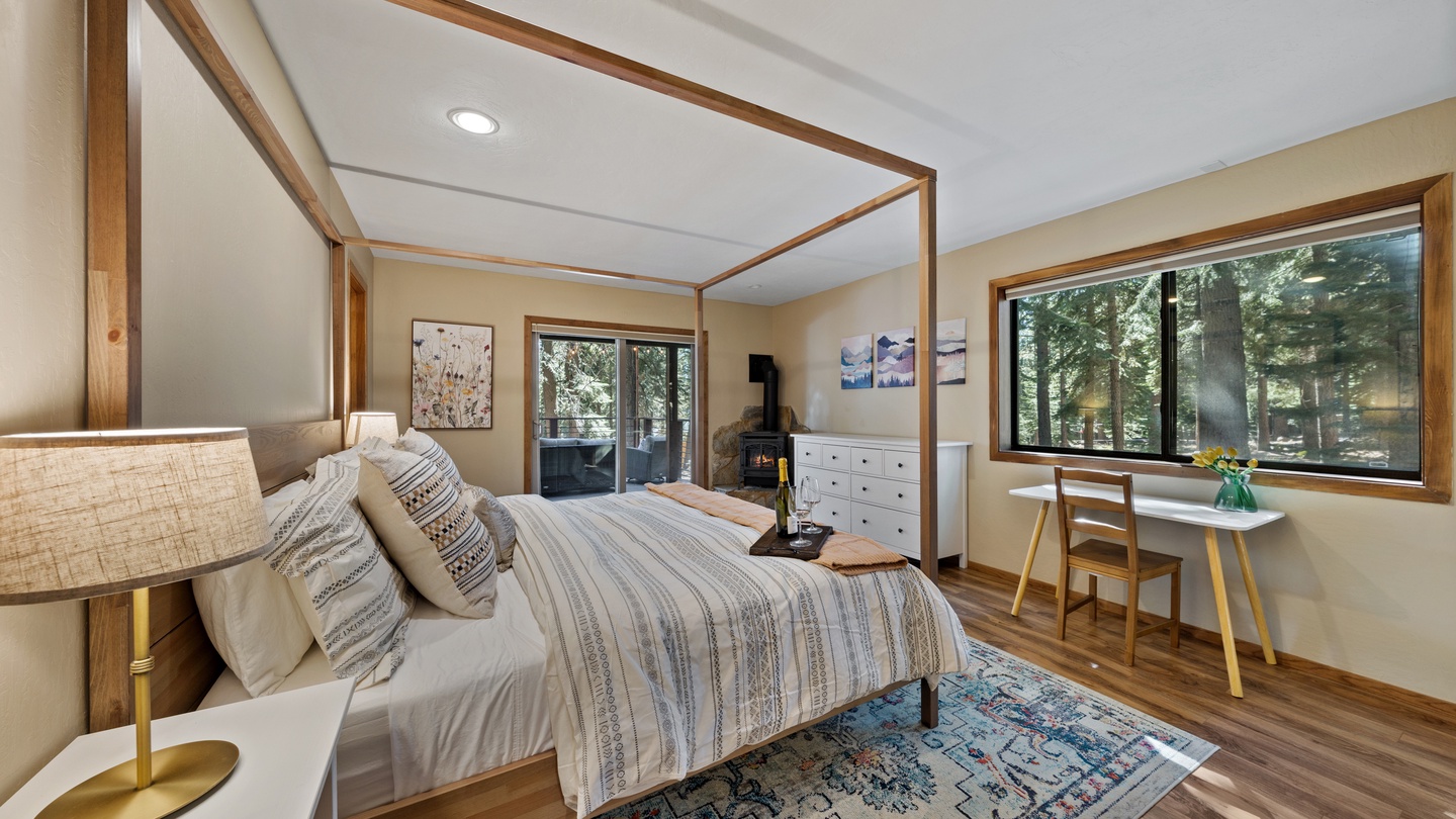 Wake up to sunlight streaming through the trees in this serene bedroom retreat. The canopy bed invites restful sleep, while the cozy workspace and forest views through both windows make this your peaceful home base for mountain getaways.
