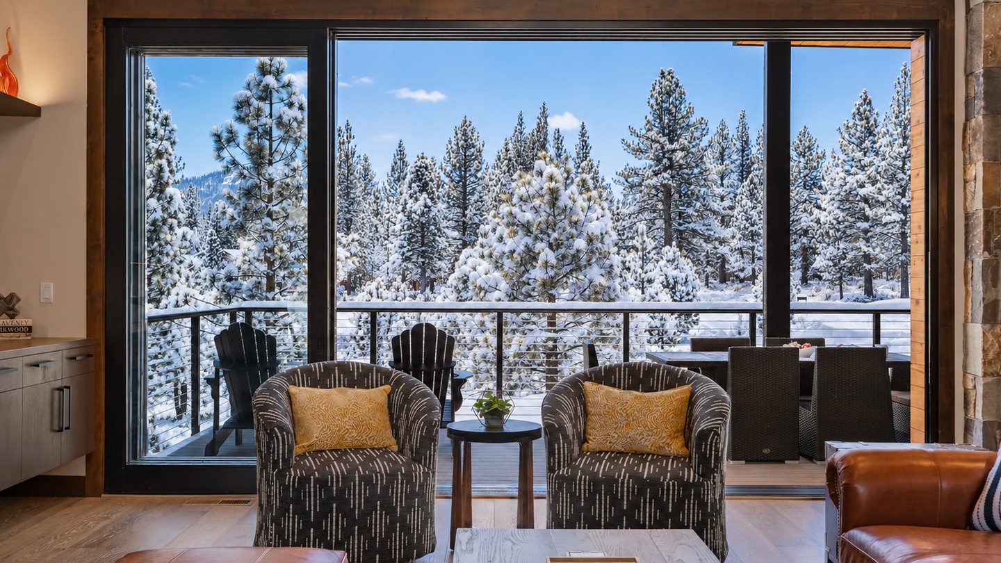 Sink into a comfy armchair with golden-hued pillows and watch snow-dusted pines through floor-to-ceiling windows, your own winter wonderland framed perfectly for cozy mountain moments.