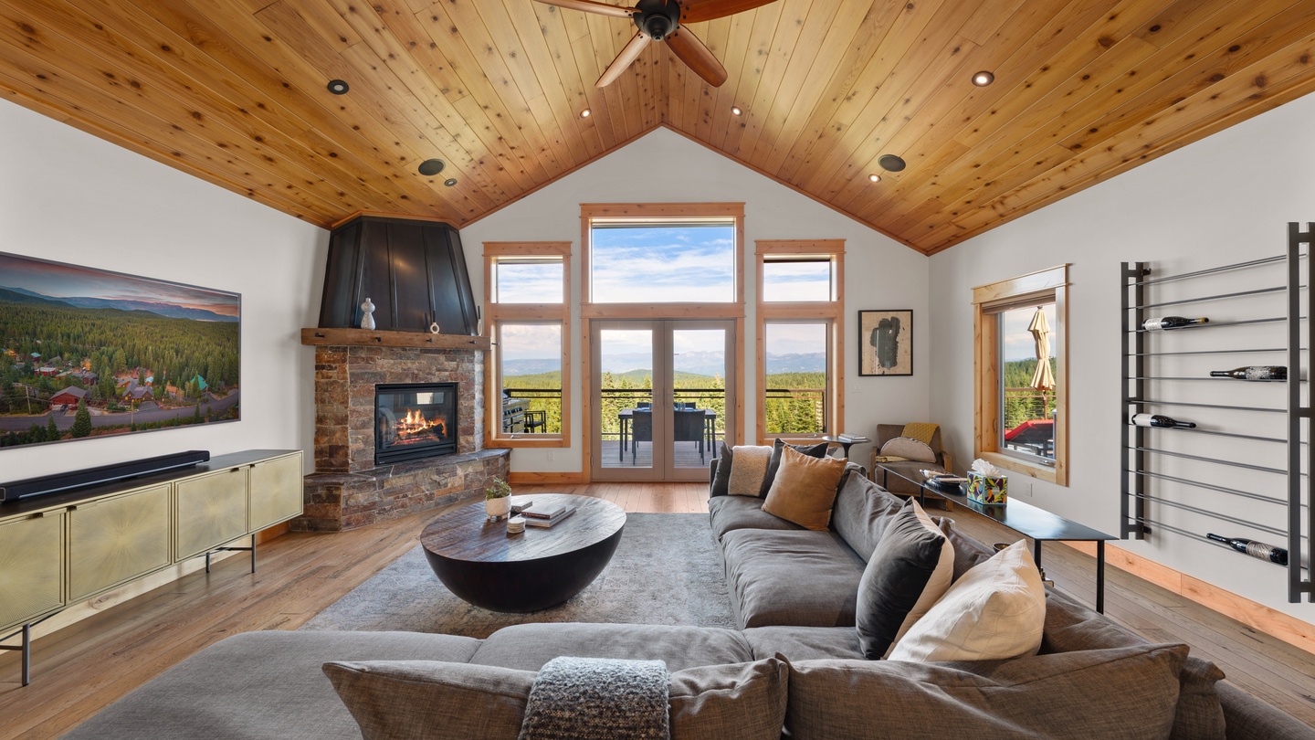 Living room with vaulted wood ceilings, fireplace, and mountain views.