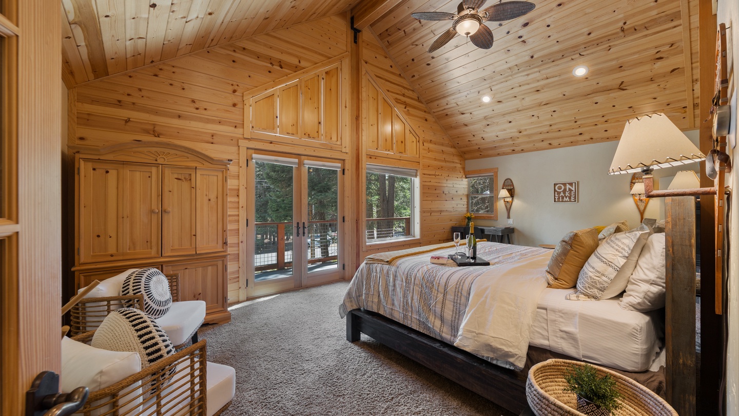 Your spacious mountain bedroom blends rustic charm with modern comfort. Vaulted pine ceilings and a cozy bed await, while French doors open to your private deck—perfect for morning coffee or starlit evenings.