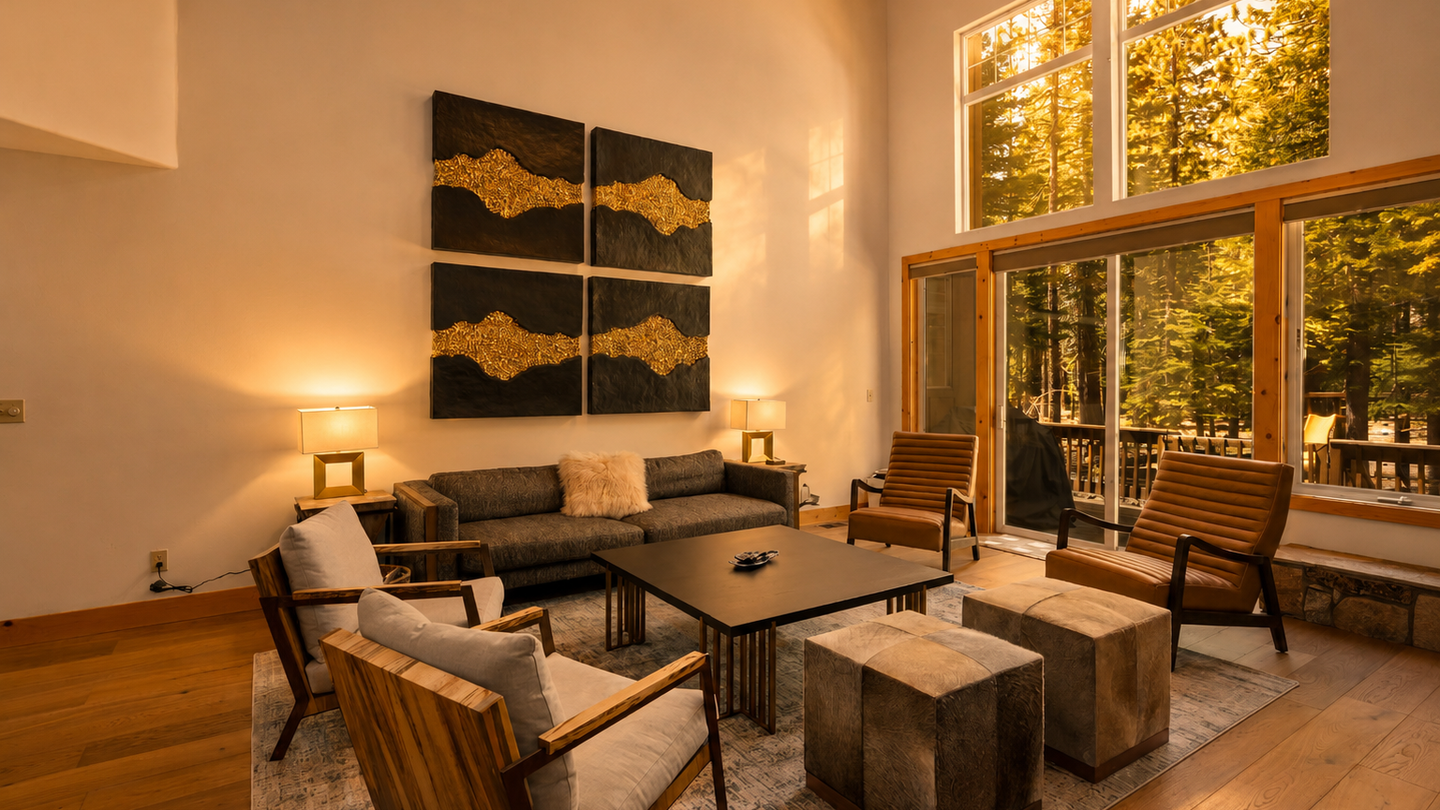 Unwind in your spacious living room where soaring ceilings and floor-to-ceiling windows frame stunning forest views. Sink into modern seating as natural light fills the space with warmth and tranquility.