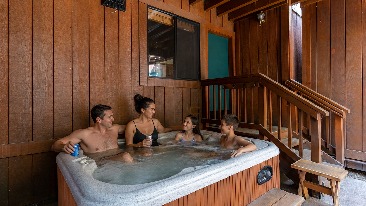 A warm wooden pavilion shelters your private hot tub, perfect for soaking under exposed beams after a day of adventure with family.