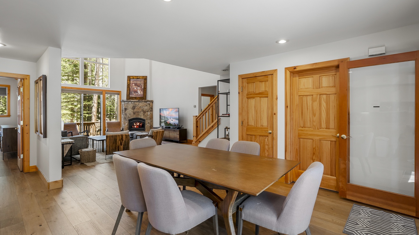 Gather with loved ones around this inviting dining table, where warm wood tones and mountain views through tall windows create your perfect vacation retreat.