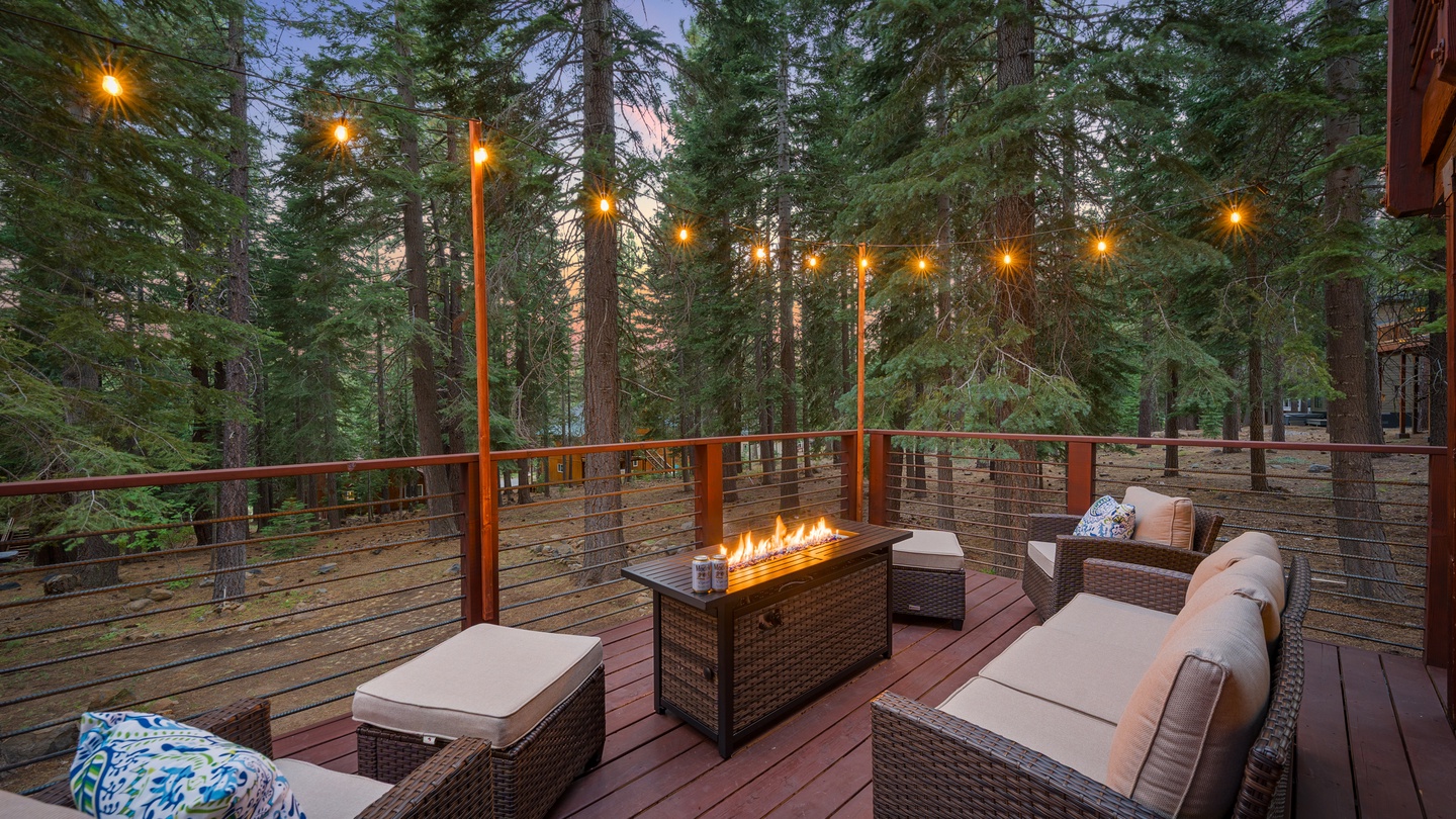 Gather around the outdoor fire feature as twilight descends through the pines. Your private deck glows with string lights, offering a cozy retreat among the trees—perfect for evening conversations and stargazing.