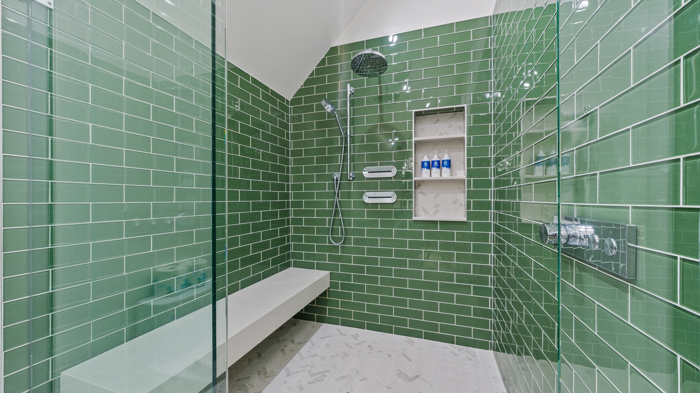 Step into your private spa-like shower, where refreshing green subway tiles surround you and dual rainfall and handheld showerheads promise a rejuvenating rinse after a day of adventure.