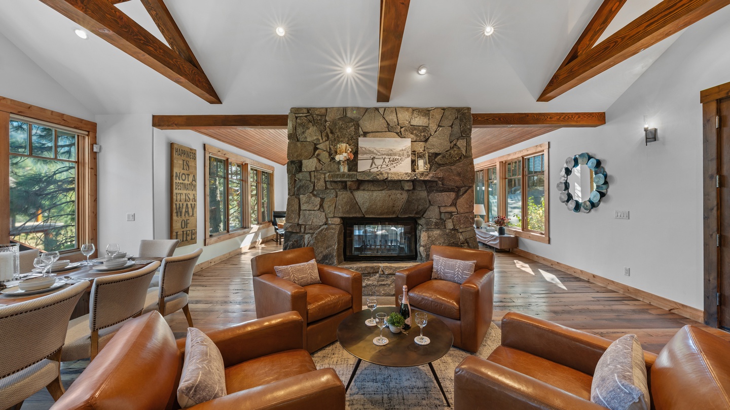 Sink into rich leather seating around the stone fireplace, where exposed beams and soaring ceilings create your perfect mountain retreat for cozy evenings together.