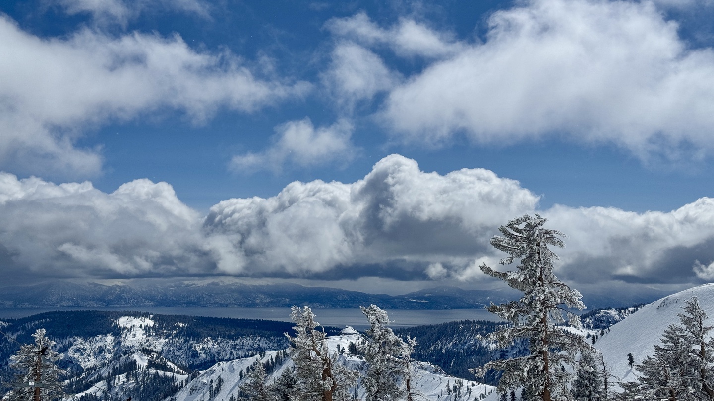 Snow-covered alpine peaks and dramatic winter clouds create a stunning mountain landscape visible from the property area.
