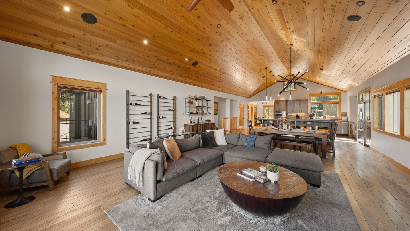 Settle into the open living space where soaring wood-paneled ceilings and natural light create a warm, inviting atmosphere. The spacious layout flows seamlessly into your fully equipped kitchen and dining area.