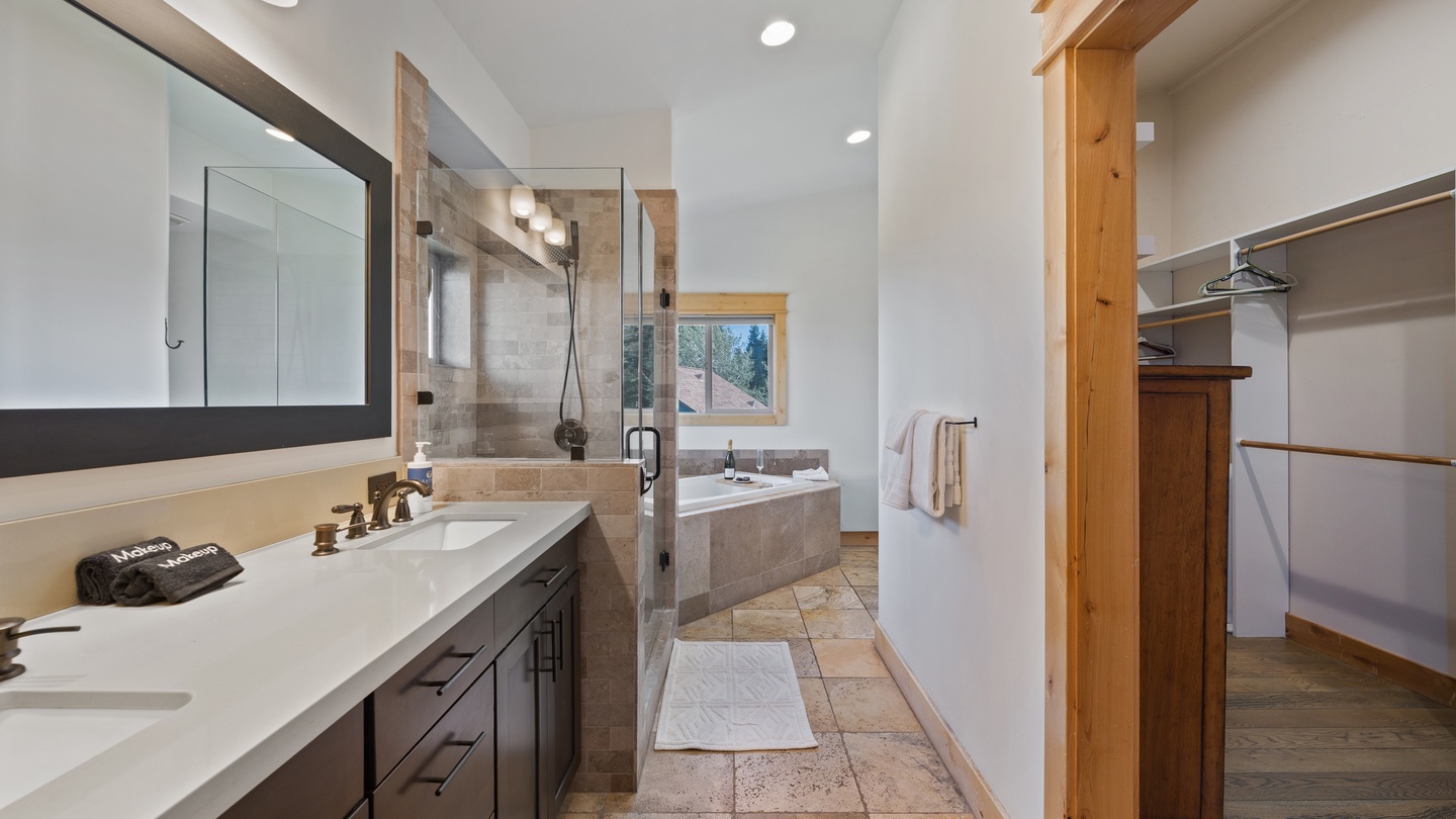 Step into your serene spa-like bathroom where warm wood tones meet modern elegance. Dual sinks offer convenience while the walk-in shower and soaking tub invite relaxation after your mountain adventures.