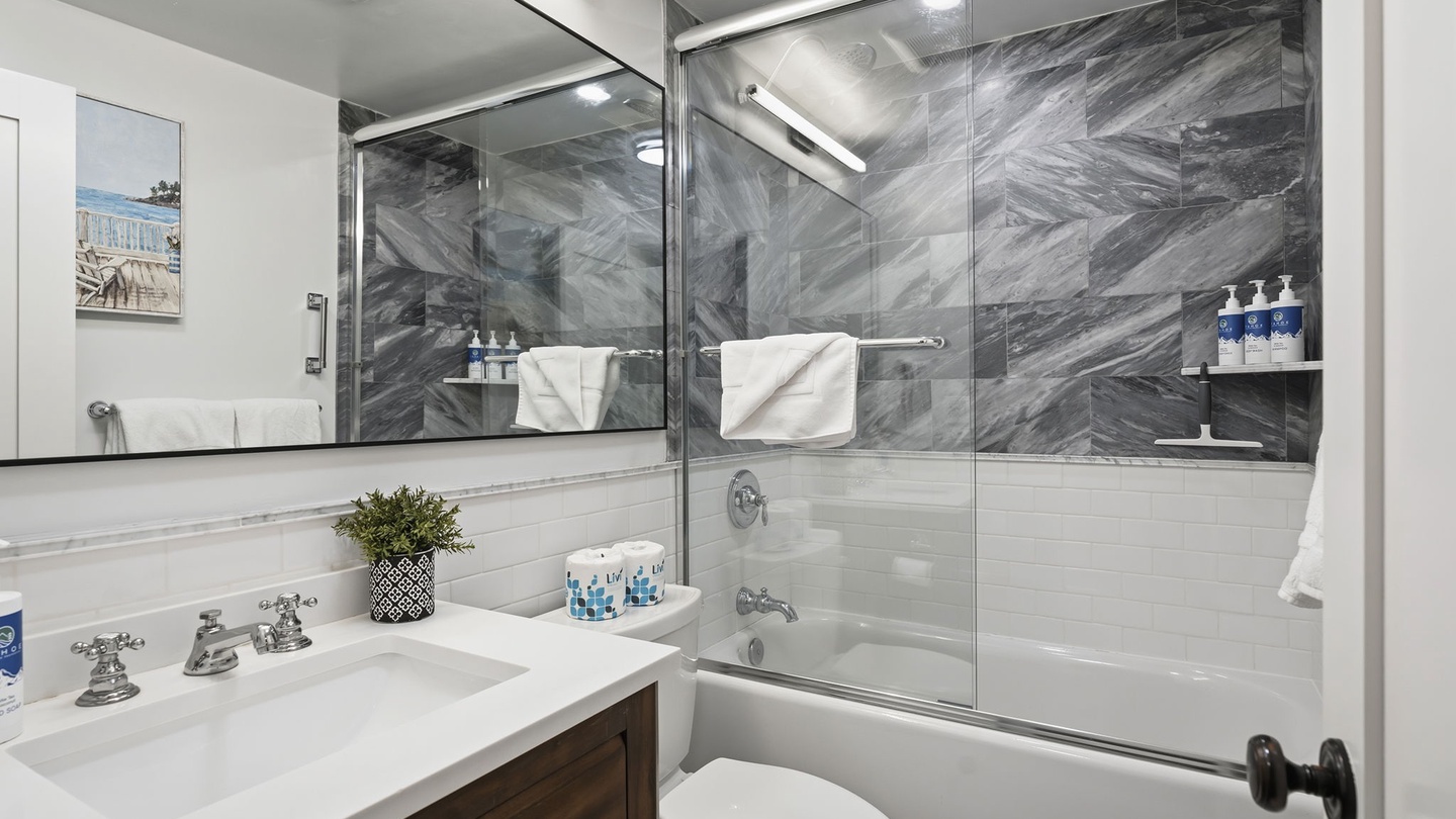 Unwind in your elegant bathroom with marble accents, rainfall shower, and luxury amenities thoughtfully arranged for your comfort.
