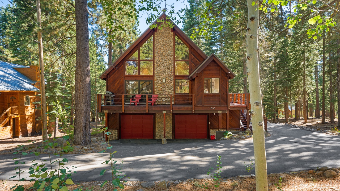 A charming mountain retreat awaits, nestled among towering pines with a welcoming two-car garage and spacious deck for relaxing after days of adventure.