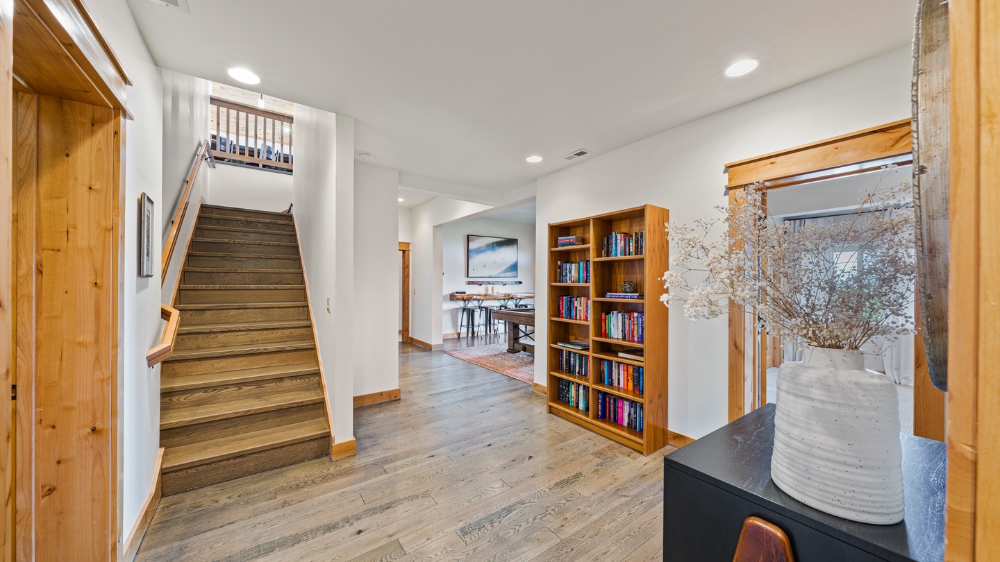 Bright, open common area with warm wood accents and a staircase leading to your next level of comfort.