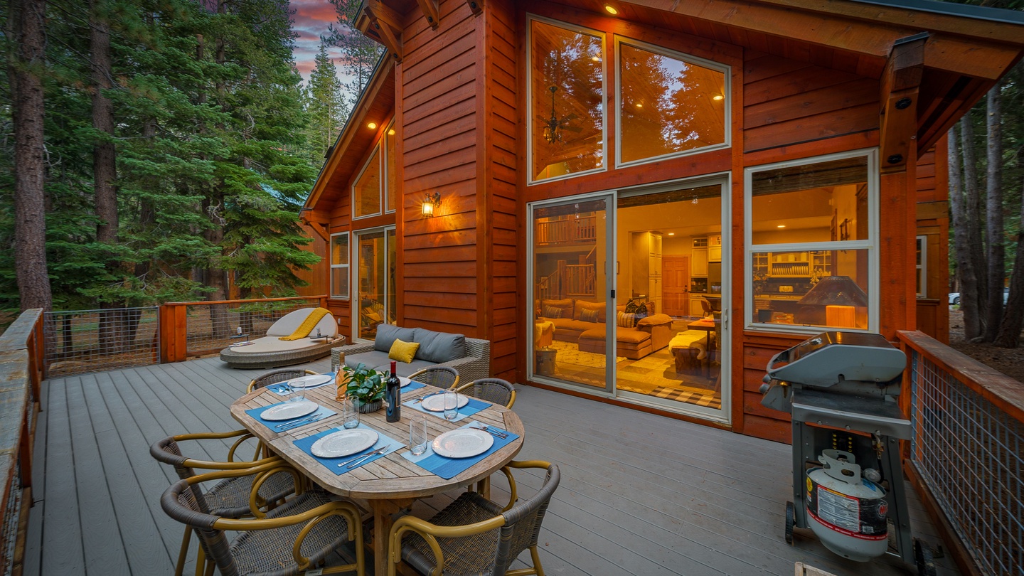 This spacious deck invites you to dine under the trees with warm cabin light glowing behind floor-to-ceiling windows. Fire up the grill and enjoy the peaceful forest setting with every comfort at your fingertips.