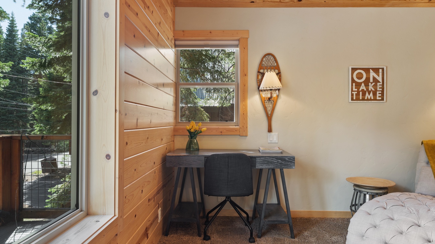 Settle into your cozy workspace with natural light streaming through knotty pine walls and views of towering evergreens. Perfect for a peaceful morning with coffee and lake vibes.