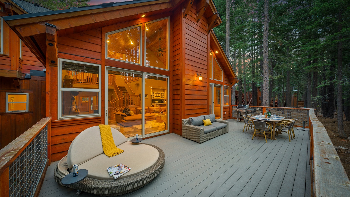Step outside to your private forest deck—a dreamy space where warm cabin lights glow against towering pines. Unwind on plush outdoor seating, dine under the sunset, and breathe in the peaceful wilderness all around you.