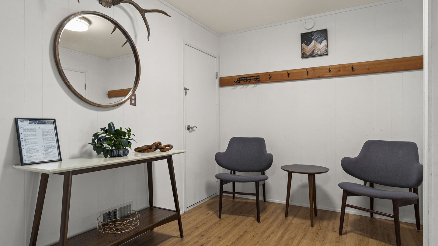 Your stylish entryway welcomes you with modern comfort—sleek seating, warm wood accents, and thoughtful touches like coat hooks for easy settling in.