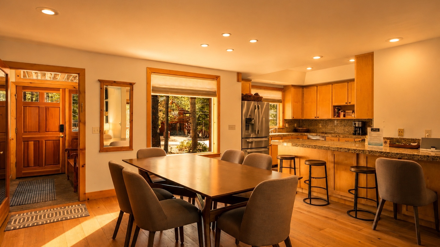Step into your welcoming open-concept living space where warm wood tones and natural light create an inviting atmosphere. Gather around the spacious dining table or unwind at the kitchen island—your perfect mountain retreat awaits.