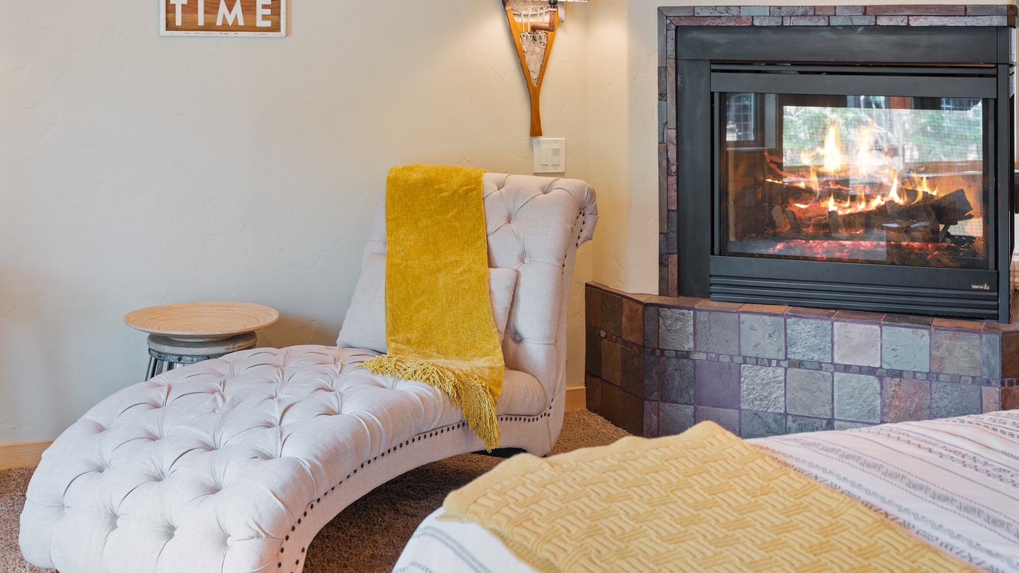 Cozy up in your elegant chaise lounge beside the glowing stone fireplace, where warmth and relaxation await after a day on the lake.