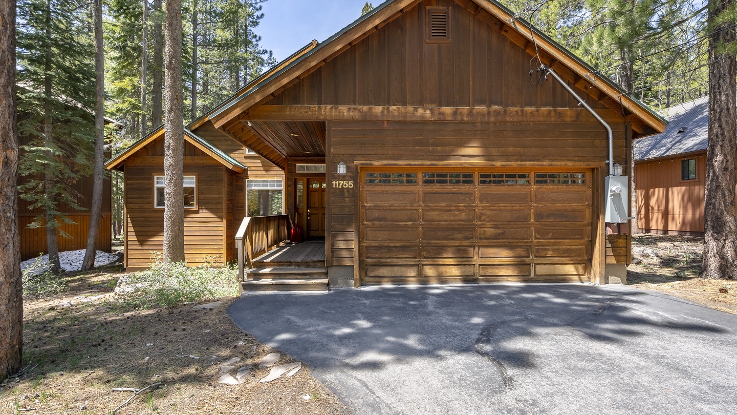 A charming mountain cabin nestled among towering pines offers easy access and ample parking, welcoming guests to a peaceful forest retreat in a serene natural setting.