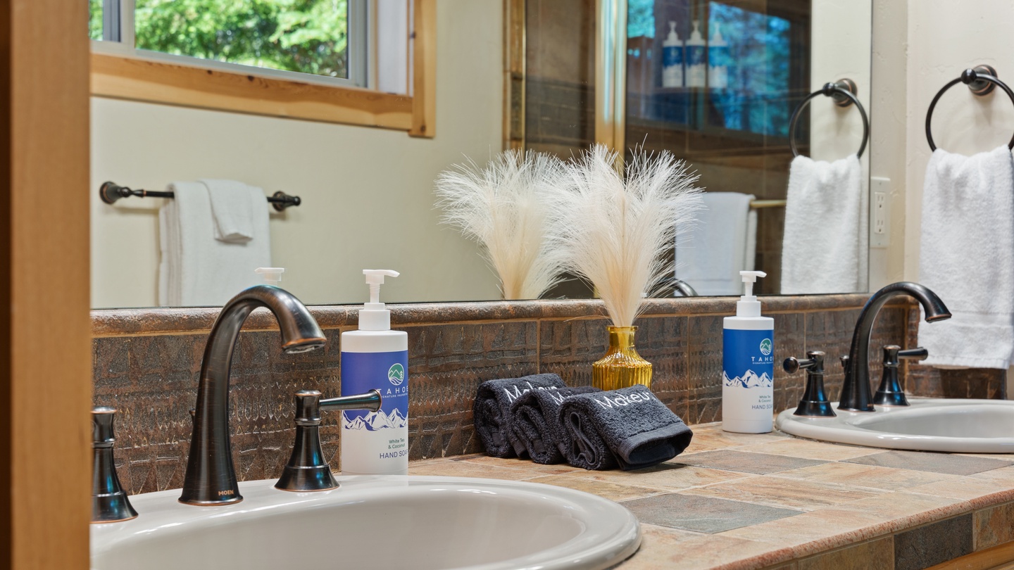 Refresh in your beautifully appointed bathroom with dual sinks, natural light, and thoughtful amenities like locally-sourced toiletries and plush towels ready for you.
