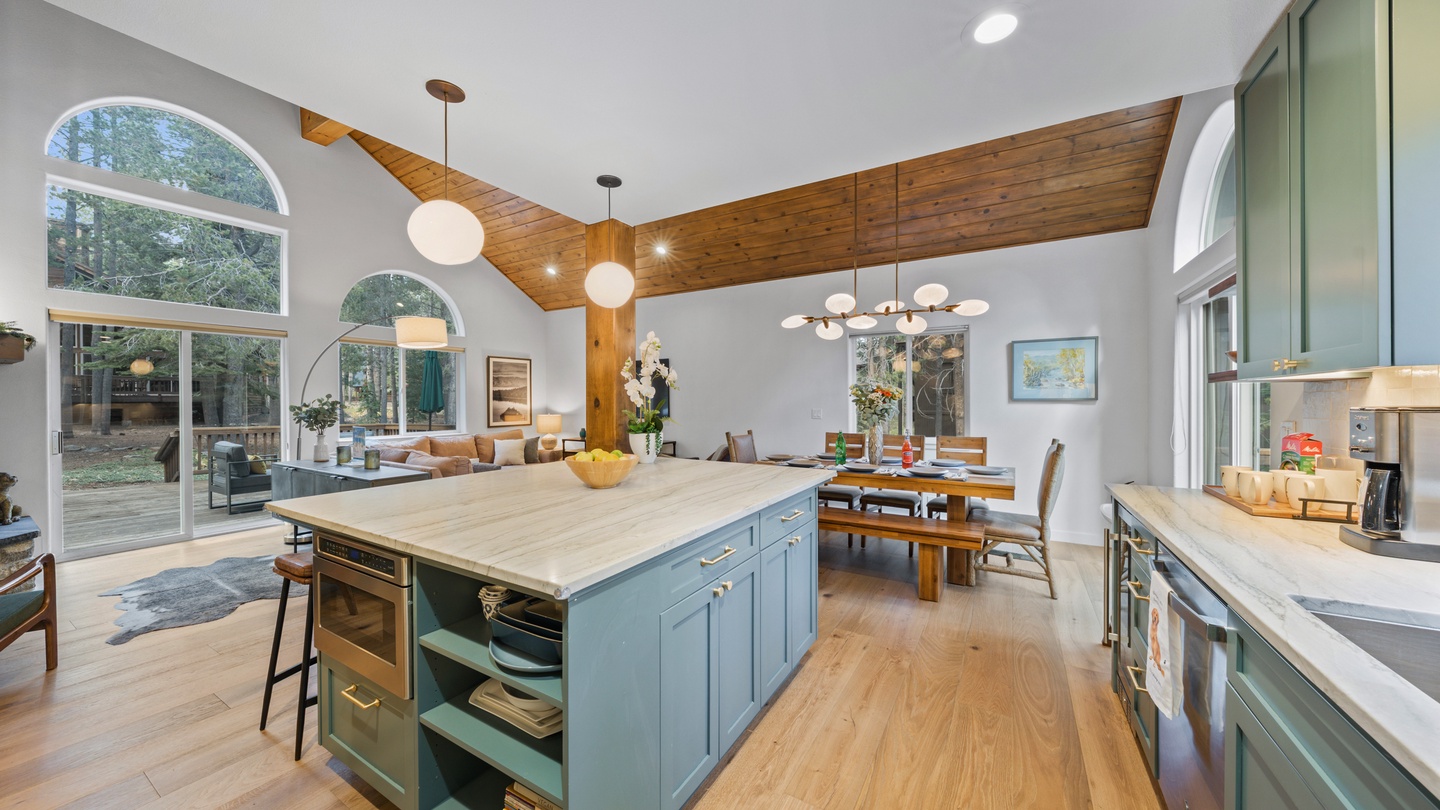 Gather around your spacious kitchen island where warm wood accents and vaulted ceilings create an inviting space for meal prep and conversation with loved ones.