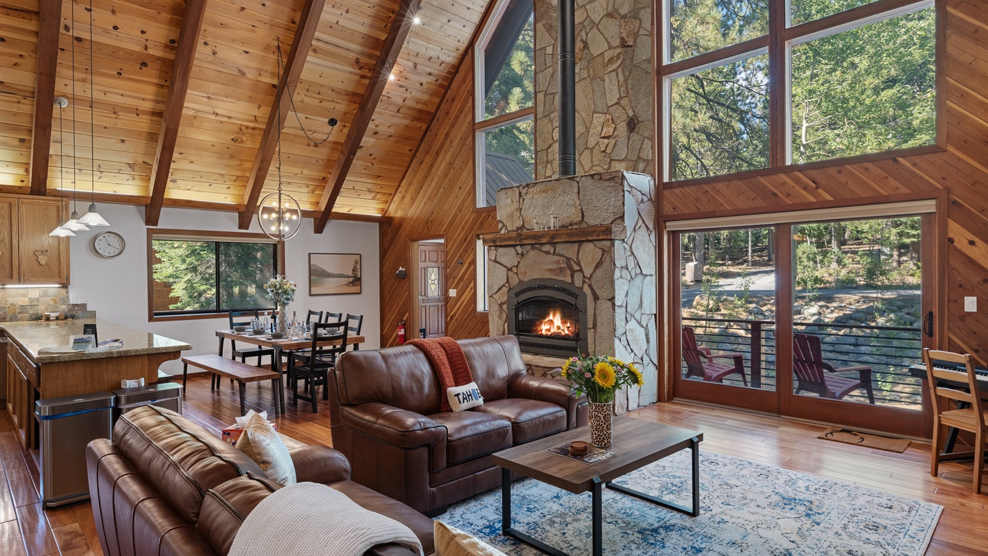 Sink into luxurious leather sofas while the fireplace crackles nearby. Soaring wood ceilings and floor-to-ceiling windows frame lush forest views, creating a warm, open sanctuary where you can truly unwind.