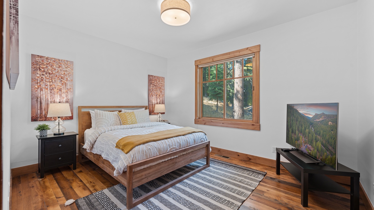 Step into your bright and peaceful bedroom retreat, where warm wood tones and soft linens invite restful nights. Wake to forest views framed by your window and enjoy all the comforts of home.