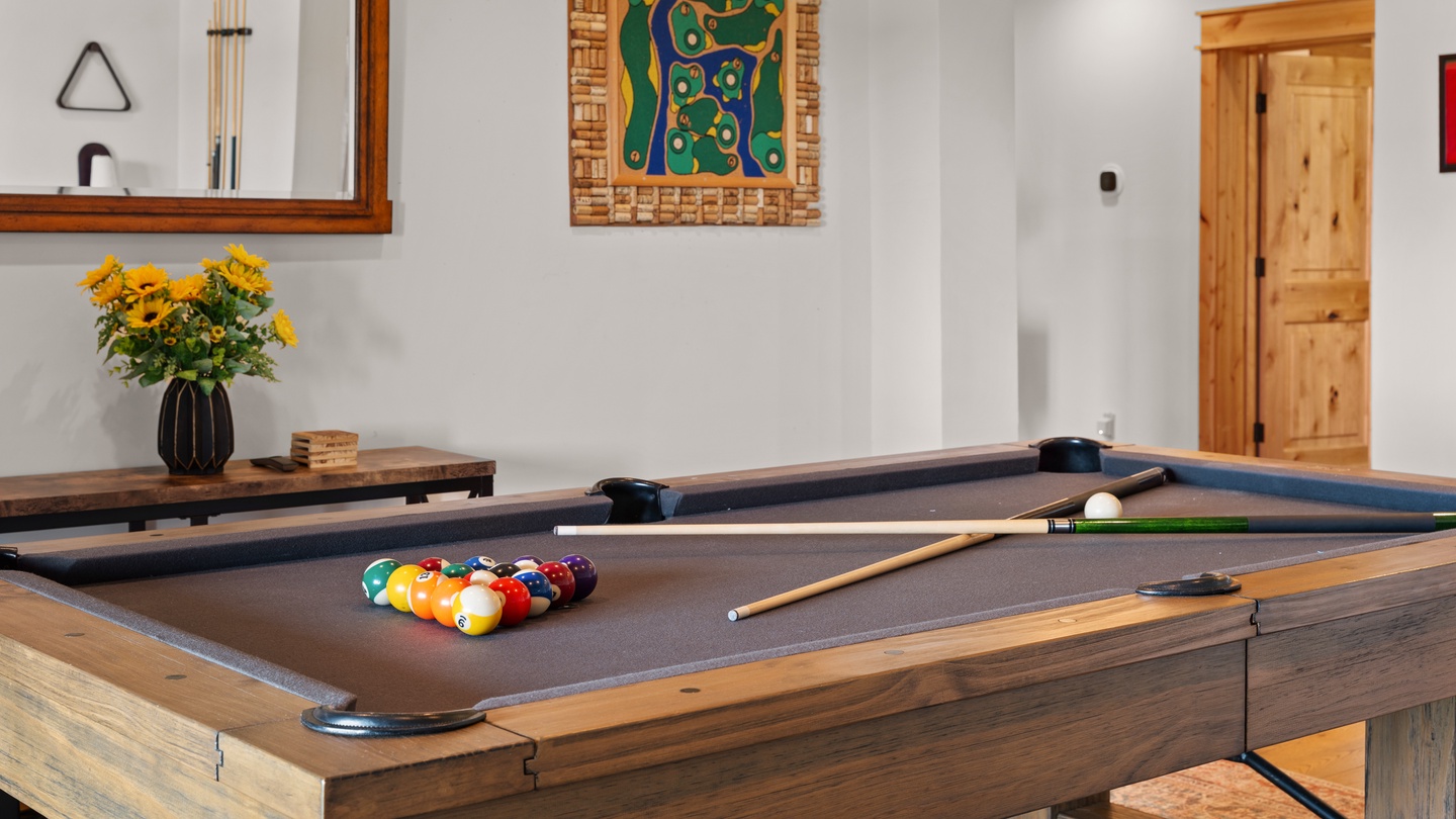 Your very own game room awaits, featuring a handsome billiards table surrounded by warm wood accents and cheerful pops of color—perfect for some friendly competition or just unwinding after a day of exploring.