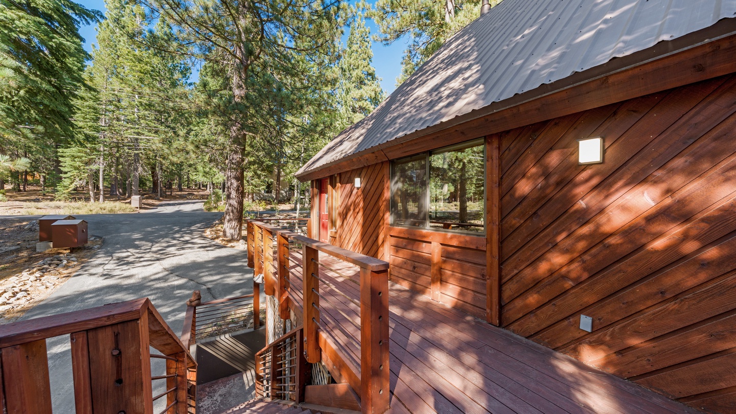 A charming A-frame cabin nestled among towering pines, featuring a welcoming wooden deck perfect for morning coffee or evening stargazing in nature's embrace.