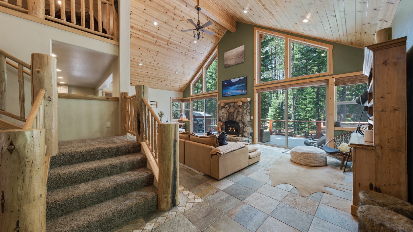 Step into your mountain retreat where soaring ceilings and sunlight streaming through oversized windows welcome you home. The fireplace creates a cozy focal point while natural wood and stone finishes surround you with warmth.