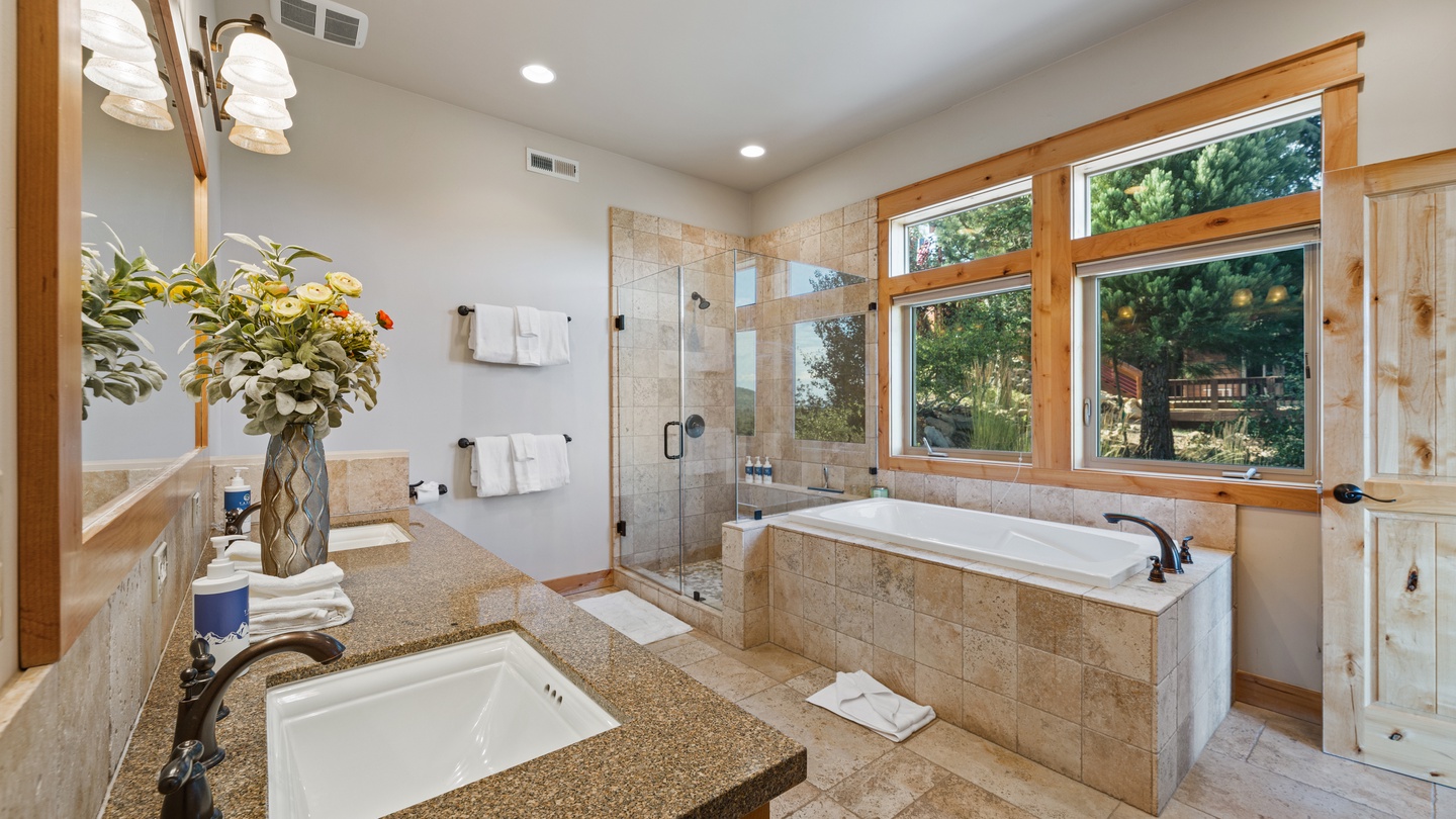 Step into a spacious, luxurious bathroom designed for your comfort—sunlight pours through large windows while you soak in the elegant tub or refresh in the walk-in shower.
