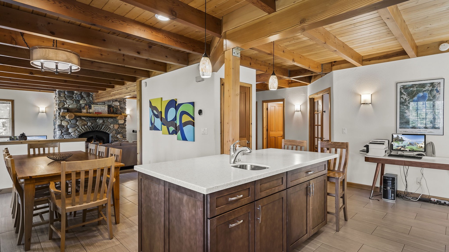 Gather around your open kitchen island or enjoy meals at the inviting dining table. Warm wood beams, a cozy stone fireplace, and charming cabin touches create a perfect mountain retreat.