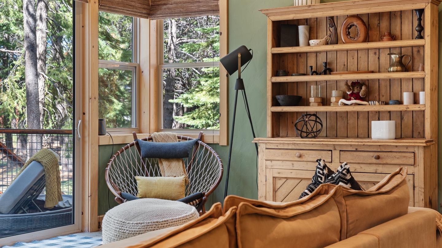 Settle into this warm, inviting living space where forest views through generous windows let you feel immersed in nature. The thoughtful rustic décor and cozy seating invite relaxation after your mountain adventures.