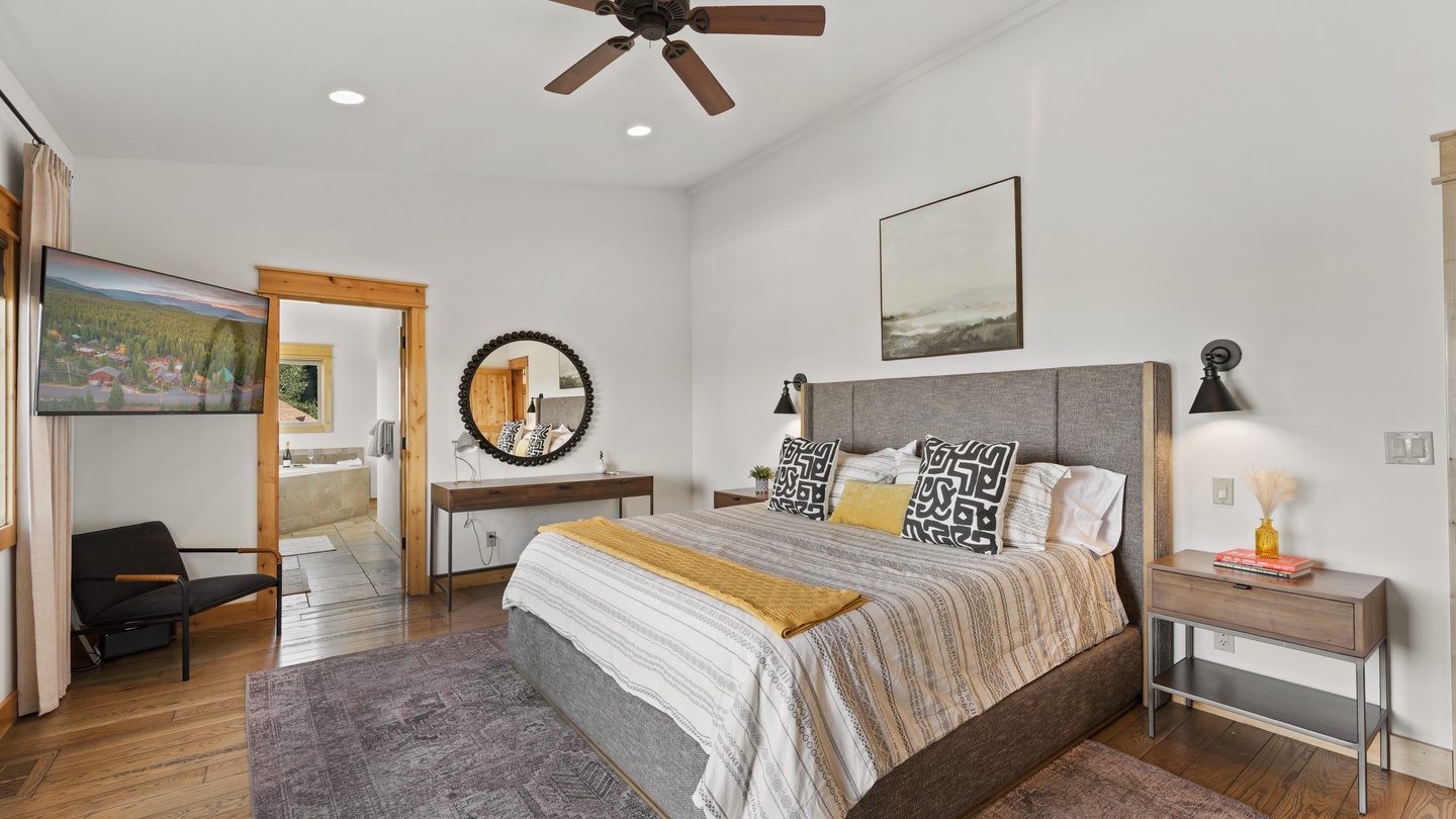 Sink into the plush king bed under a warm glow from bedside lamps, with a ceiling fan to keep you cool. Your ensuite bathroom awaits just steps away, and the clean, modern décor invites instant relaxation.